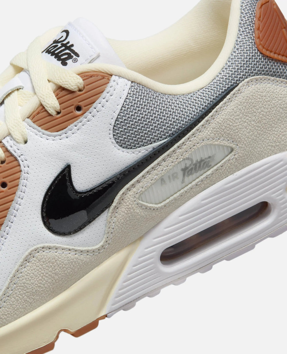 Detail of Patta x Nike Air Max 90 SP sneaker featuring the black Swoosh, textured overlays, and Air Patta badge.